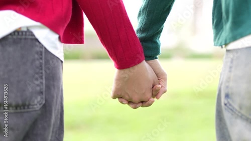 A couple holding hands in a park