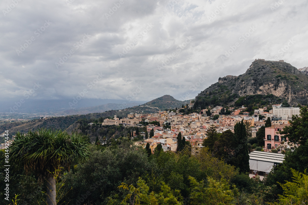 Obraz premium Panoramic View of Taormina, Sicily with Mountains and Historic Architecture