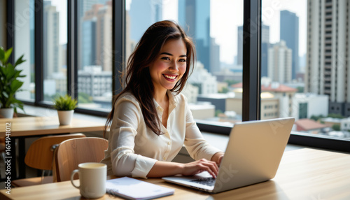 Focused businesswoman working on laptop in modern office urban landscape inspirational environment bright viewpoint