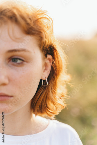 Schilderij op canvas Close-Up of Woman with Red Hair Wearing Silver Earring
