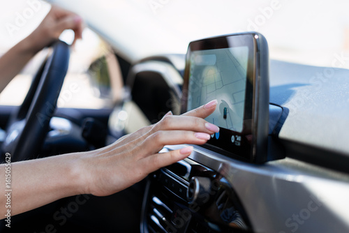 Canvas Print Woman driving car using navigation system on dashboard touchscreen