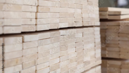 Rows of neatly stacked pine timber planks in a workshop or warehouse, showing clean edges, uniform size, and natural grain ready for woodworking or construction use