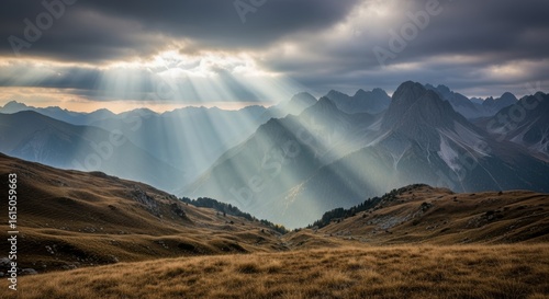 Dramatic crepuscular rays pierce through stormy mountain clouds