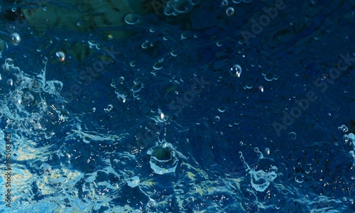 Clean blue water splash in motion with many bubbles and drops background