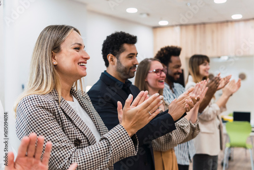 Happy business people clapping hands after a presentation in office