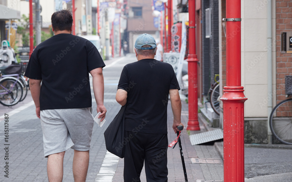 Obraz premium 夏の都市の商店街で歩くシニア男性の姿