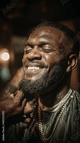 Man enjoys grooming experience at a barbershop with a stylish beard and perfect haircut under warm lighting