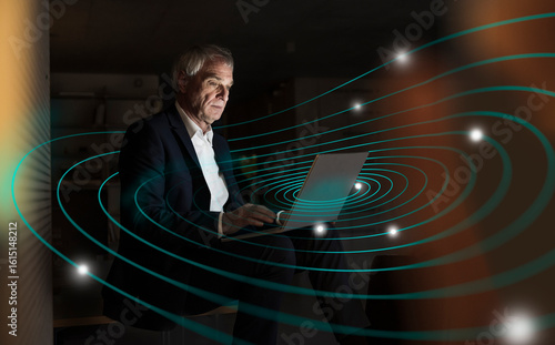 Digital composite image of senior businessman using laptop with futuristic network