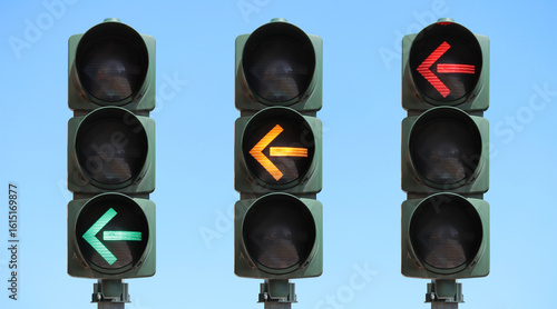 Sequence of a traffic light with left turn arrow: green, yellow and red light. Set of traffic lights with the sky as background.
