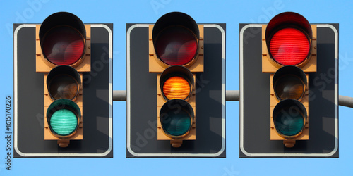 Traffic light sequence: green, yellow and red light, with back plate and bigger red light with the sky as background.
