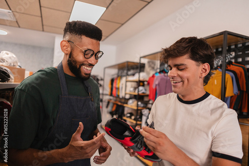 Shop assistant showing cycling shoes to customer in bike shop