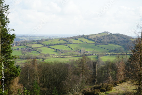 North East Derbyshire, England – March 6 2024: Rolling green hills and stone farm buildings under early spring light