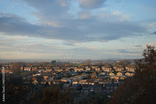 Dronfield, North East Derbyshire, England – December 3 2023: Suburban rooftops panorama captured at sunset during winter overlooking Dronfield area.