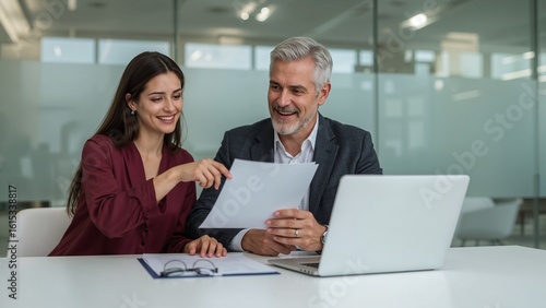 Wallpaper Mural Two colleagues collaborating on a project, reviewing documents and discussing ideas using a laptop Torontodigital.ca