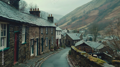 Quaint village street winding uphill, stone houses, overcast day