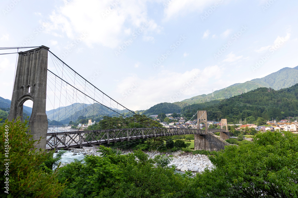 Fototapeta premium 桃介橋,吊り橋,長野県,南木曽町,木曽川,橋,歴史的建造物,文化財,観光地,山,山並み,緑,森林,自然,川,河川,石垣,田舎,風景,夏,空,雲,日本,景勝地,旅行,観光,建築,土木,橋梁,集落,田園,渓谷,川辺,緑地,岩,