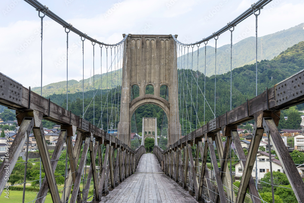 Obraz premium 歴史的な木造吊り橋と山の風景が美しい長野県の桃介橋