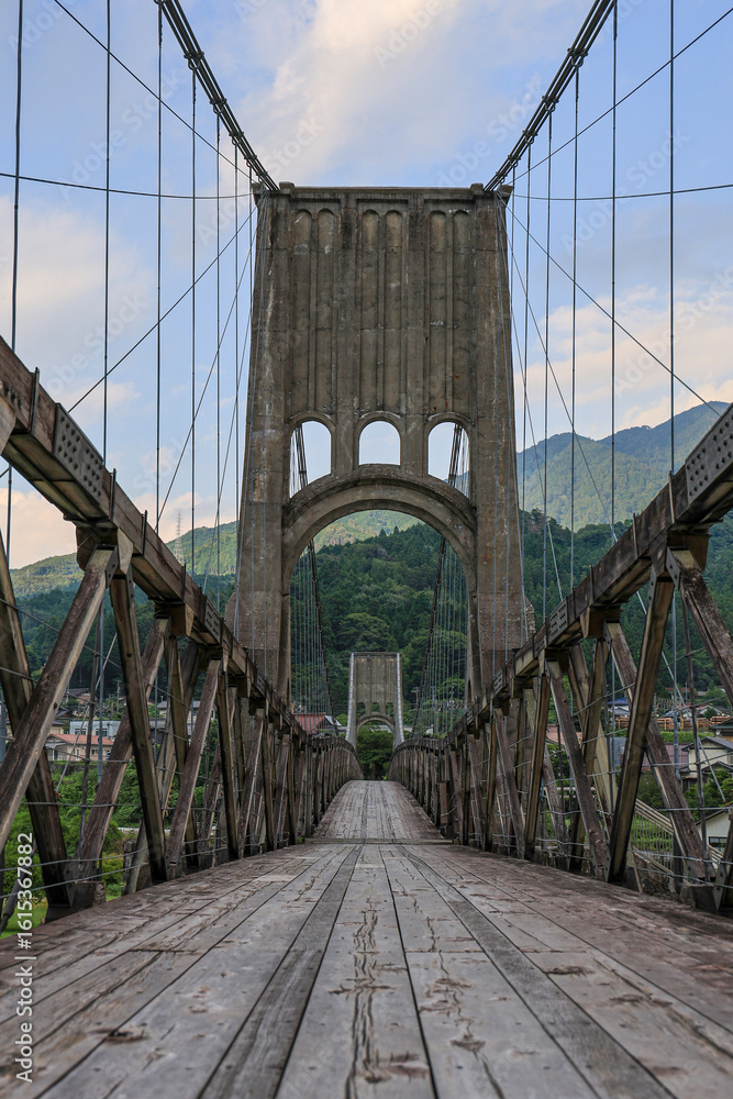 Obraz premium 歴史的な木造吊り橋と山の風景が美しい長野県の桃介橋