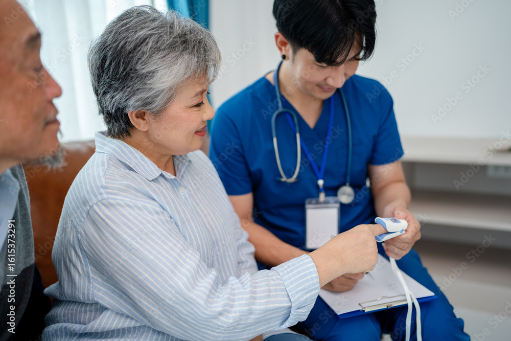 Obraz premium senior woman using pulse oximeter to measure blood oxygen instructed by physiotherapist. home caregiver nurse visit retire couple patient for health check up recovery process medical service
