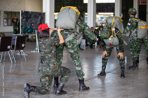 Photography Soldier adjusting parachute gear for a fellow paratrooper before jump training