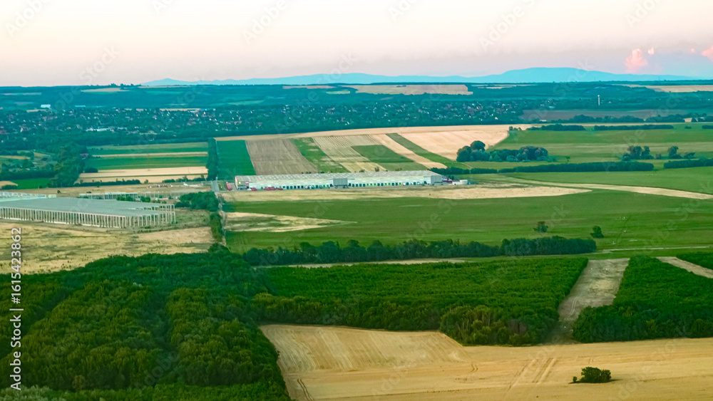 Obraz premium Scenic aerial view of rural landscape with golden fields at warm sunset light