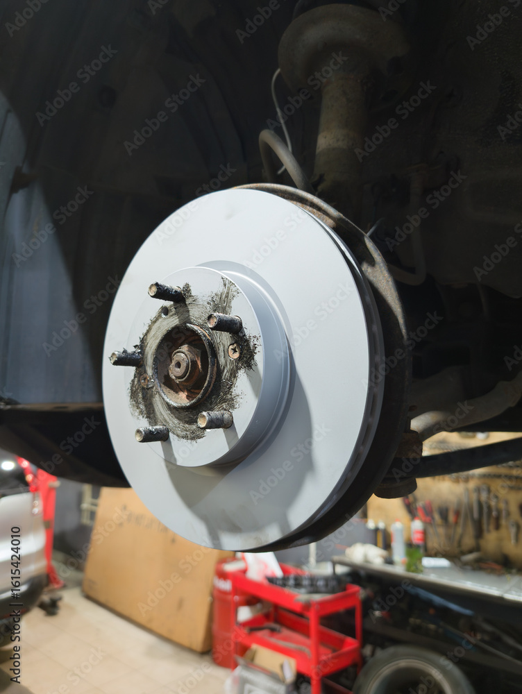 Car brake disc closeup in auto repair garage after replacement service Car brake disc closeup in auto repair garage after replacement service