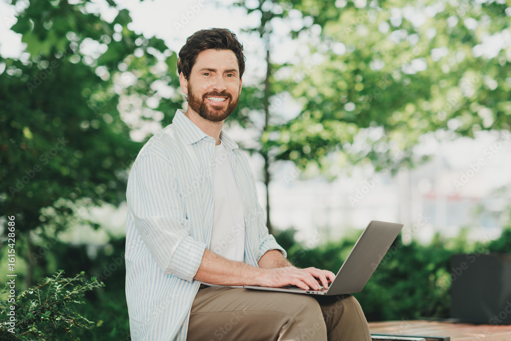 Handsome professional man working with a laptop outdoors amidst greenery, enjoying a casual lifestyle and fresh air Handsome professional man working with a laptop outdoors amidst greenery, enjoying a casual lifestyle and fresh air