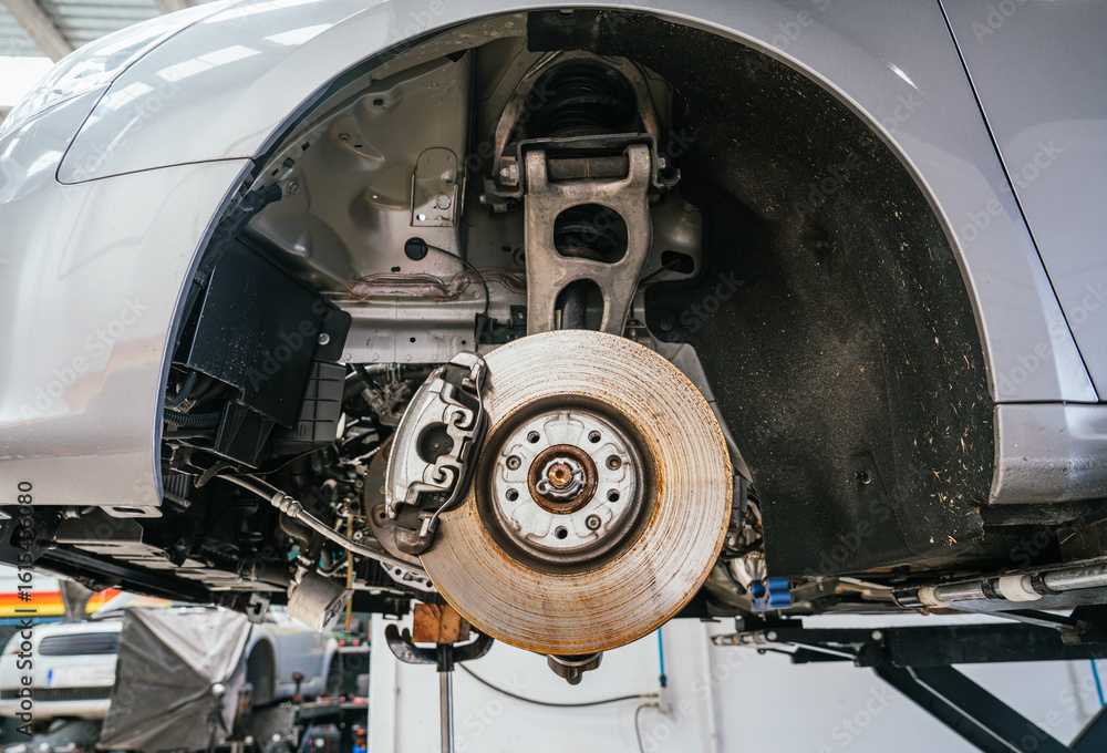 Exposed wheel housing and brake components during vehicle inspection Exposed wheel housing and brake components during vehicle inspection