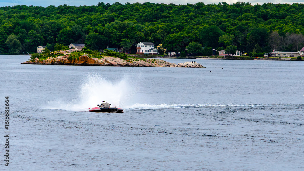Fototapeta premium Single red and white hydroplane boat throwing spray on the water
