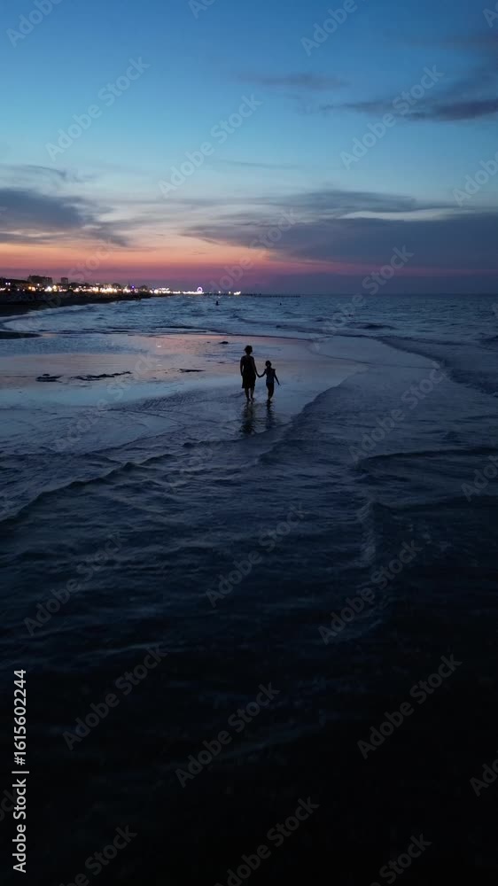 Ocean Serenade: A silhouette of two figures strolling along the shoreline. The sky is ablaze with the captivating hues of twilight. Rimini, Emilia-Romagna Ocean Serenade: A silhouette of two figures strolling along the shoreline. The sky is ablaze with the captivating hues of twilight. Rimini, Emilia-Romagna