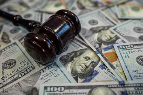 Judge's gavel on pile of US dollar bills – Concept of justice, corruption, bribery or court fines
