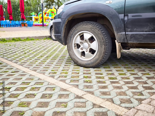 Eco-friendly car parking area designed with permeable pavement and adjacent recreational amenities for families