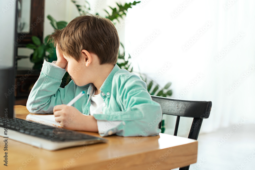 Kids and gadgets. Distance learning. Back to school. sad Boy and laptop at home. Kids and gadgets. Distance learning. Back to school. sad Boy and laptop at home.