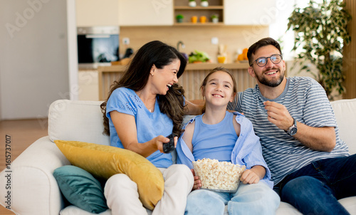 Family enjoying a cozy movi...