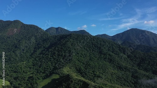 Aerial view of a mountainous and preserved region of the Atlantic Forest, a tropical rainforest in Rio de Janeiro, Brazil. The beauty and biodiversity are the highlights.