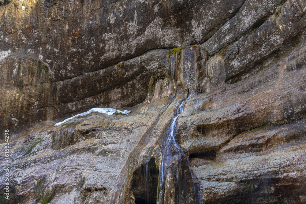 Fototapeta premium Chegem waterfalls in the mountain gorge of Kabardino-Balkaria. Smooth rocks in the mountains as a result of the descent of water from the peaks. The water flows down the smooth rocks.