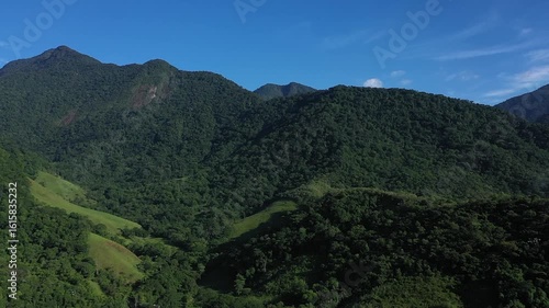 Aerial view of a mountainous and preserved region of the Atlantic Forest, a tropical rainforest in Rio de Janeiro, Brazil. The beauty and biodiversity are the highlights.