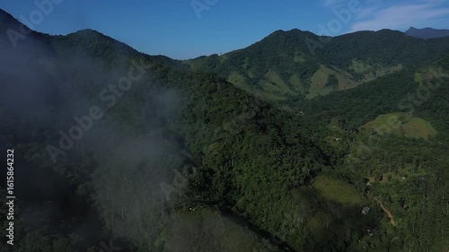 Aerial view of a mountainous and preserved region of the Atlantic Forest, a tropical rainforest in Rio de Janeiro, Brazil. The beauty and biodiversity are the highlights.