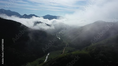 Aerial view of a mountainous and preserved region of the Atlantic Forest, a tropical rainforest in Rio de Janeiro, Brazil. The beauty and biodiversity are the highlights.