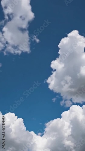 White clouds drifting across a clear blue sky in a smooth time-lapse sequence. Peaceful and natural weather background, perfect for cinematic transitions, nature projects, or atmospheric video element