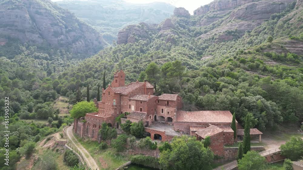 custom made wallpaper toronto digitalAerial view of buildings nestled in a lush forest with mountains, contrasting red brick with green canopy, El Marquet de les Roques, Spain.