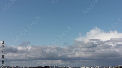 Time lapse. High summer blue sky with fast moving clouds over the city