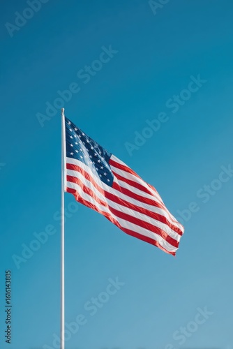 minimalistic image of american flag gently waving in front of clear blue sky to symbolize patriot day with ample copy