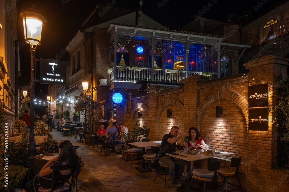 Φωτογραφία Tbilisi, Georgia - Sept 4, 2024: Night street restaurants in old Tbilisi feature red brick buildings and open air eating