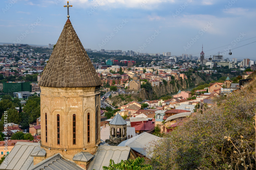 Φωτογραφία Urban panorama showing the juxtaposition of Upper Betlemi Church with contemporary structures like the Peace Bridge and the Rike Park Concert Hall, showcasing Tbilisi's evolving identity