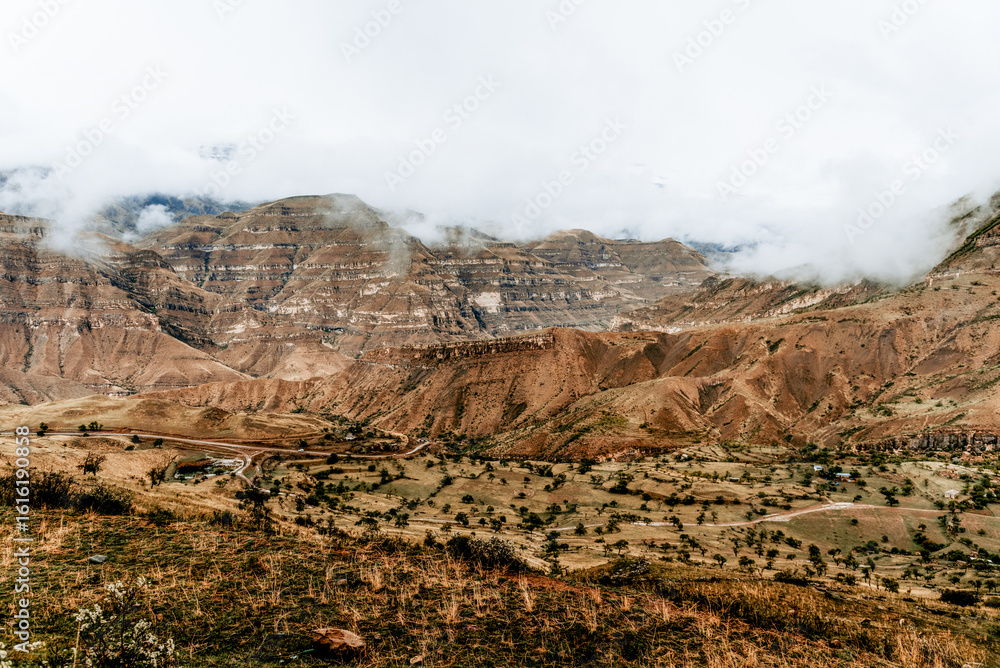Fototapeta premium Landscape of Dagestan mountains, mountain range in haze summer Russia