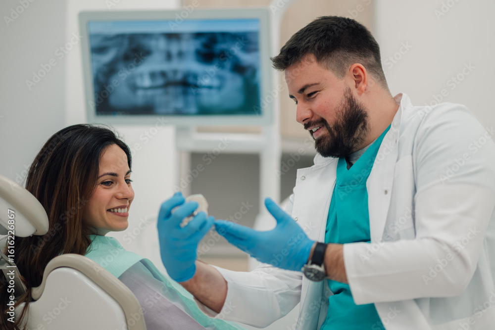 Ταπετσαρία Dentist showing teeth model to patient in modern clinic