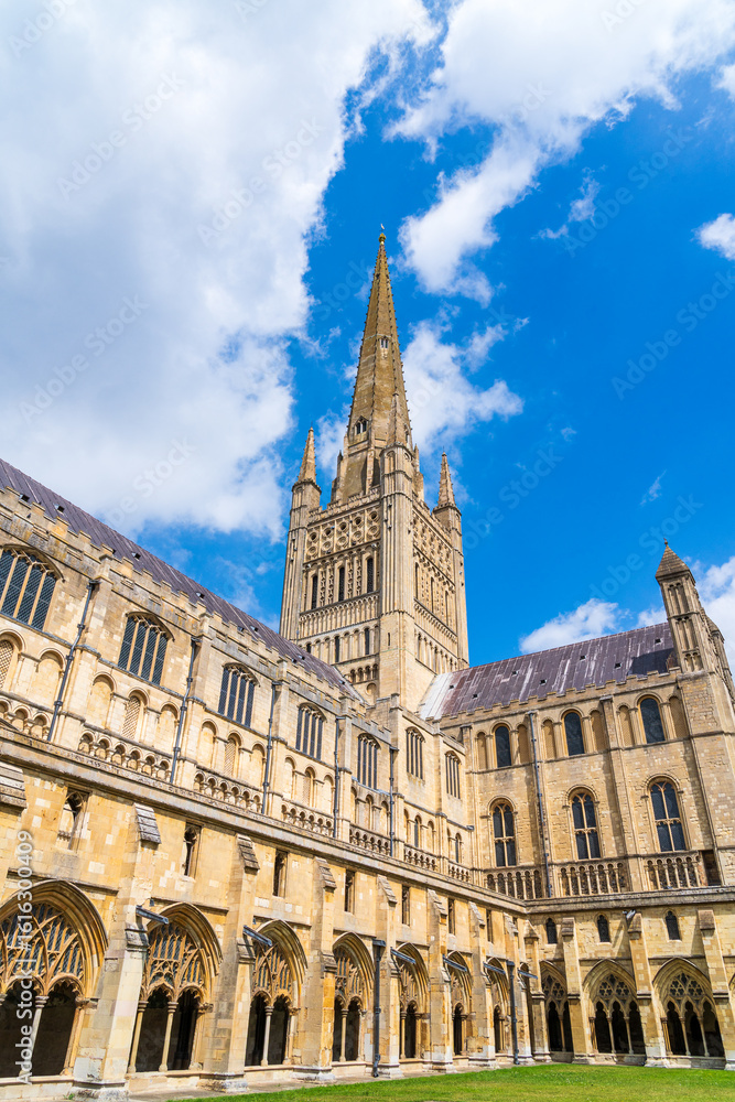 Fototapeta premium A view of the Spire and cloisters at Norwich Cathedral, Norfolk, UK in portrait orientation on a summer day