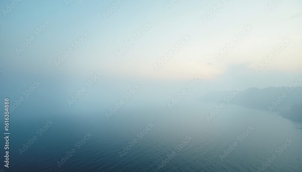 Fototapeta premium Misty Coastal Scene at Dawn with Calm Waters and Soft Colors