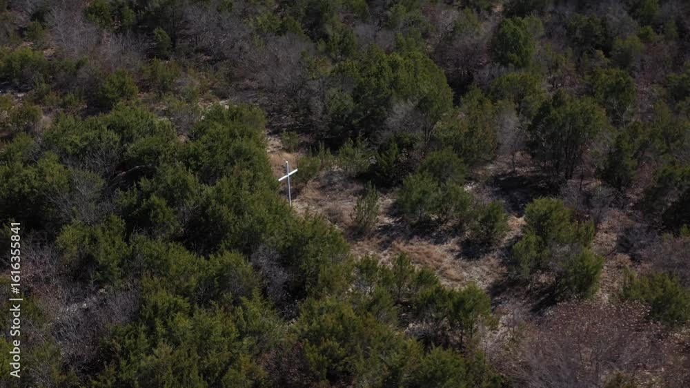White Wooden Cross Surrounded By Brush and Trees in the Rural Countryside Zoom Out Drone View White Wooden Cross Surrounded By Brush and Trees in the Rural Countryside Zoom Out Drone View